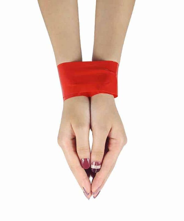 Mãos femininas com pulseira vermelha e unhas decoradas, símbolo de elegância e estilo.