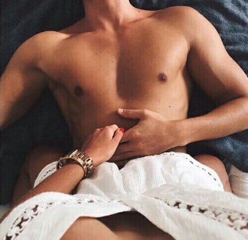 Mulher sentada em cima do homem na cama