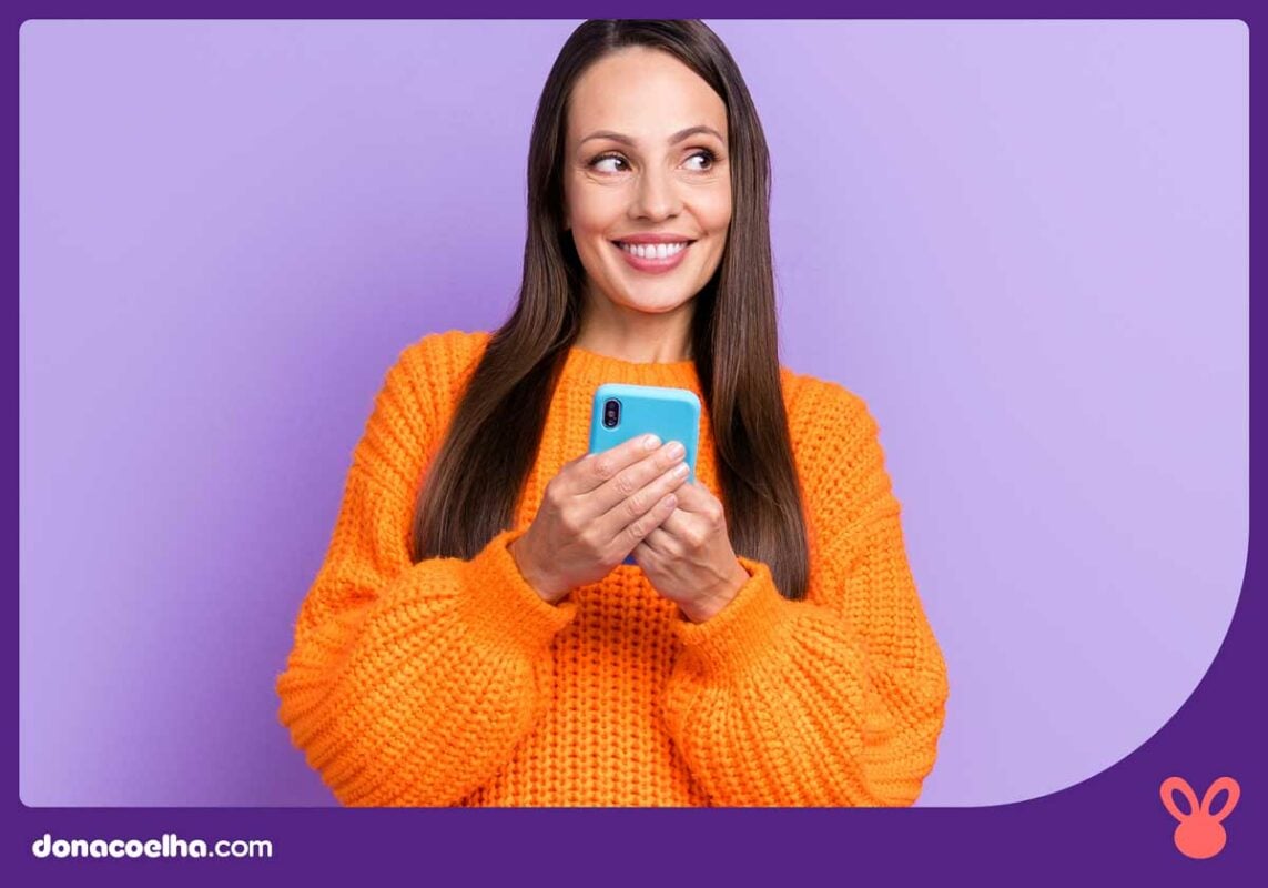 Mulher sorrindo após olhar uma mensagem no celular
