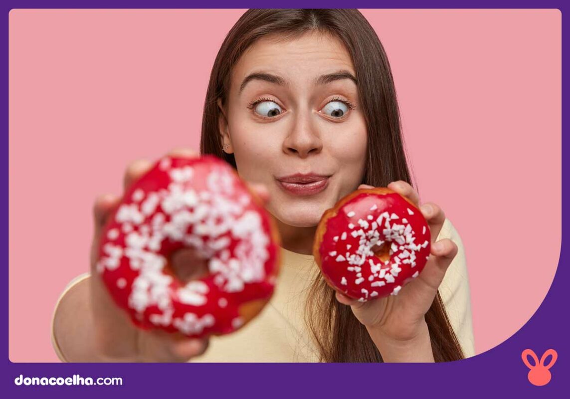 Mulher segurando duas rosquinhas e está de olho muito focado em uma delas