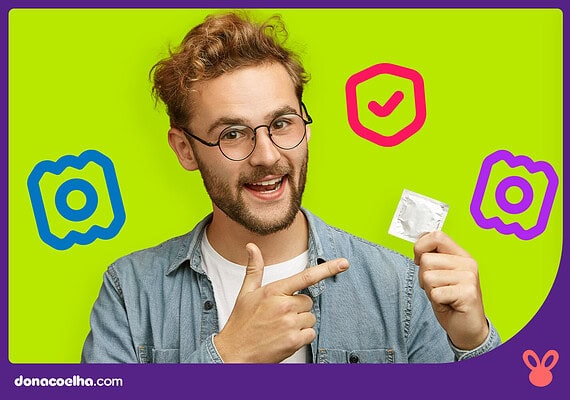 Homem segurando um preservativo em fundo colorido
