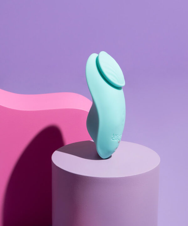 Snuggy, protetor diário para cuidados íntimos femininos, em tom azul claro, apresentado sobre plataforma rosa em cenário minimalista com combinação de cores suaves.
