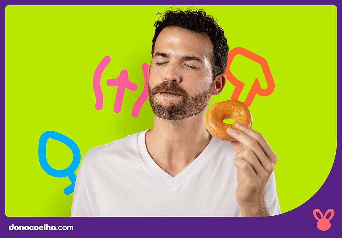 Homem saboreando um donut em fundo colorido