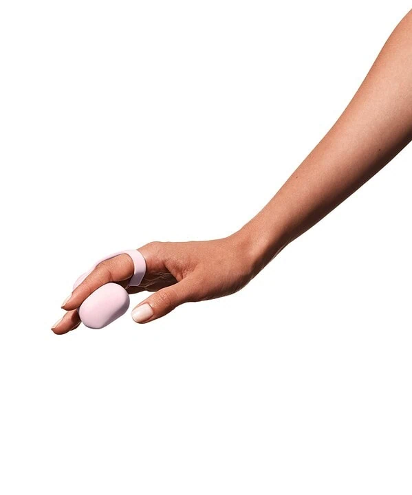 Bola de massagem rosa na mão, ideal para alívio de tensões musculares. Produto de bem-estar da Dona.