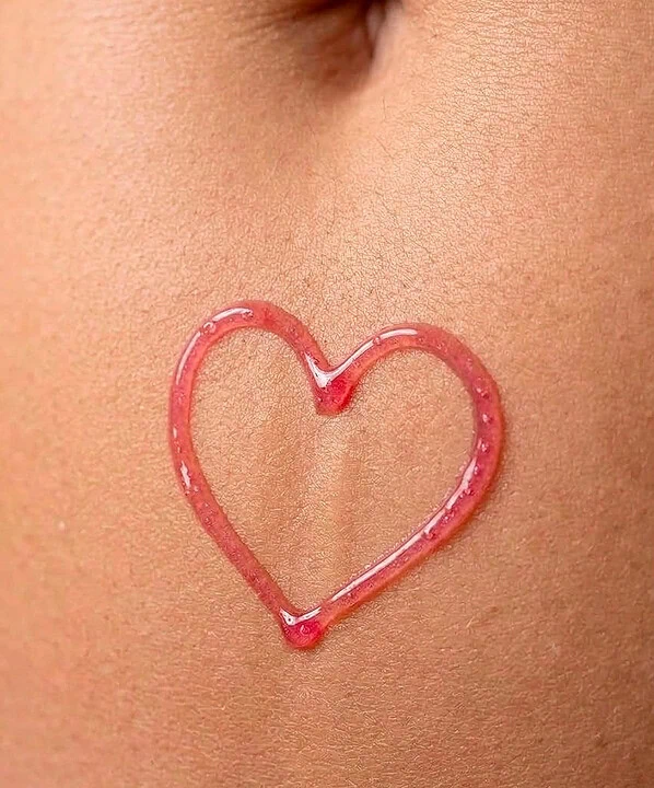 Coração de glitter rosa desenhado na pele com brilho e detalhes delicados.