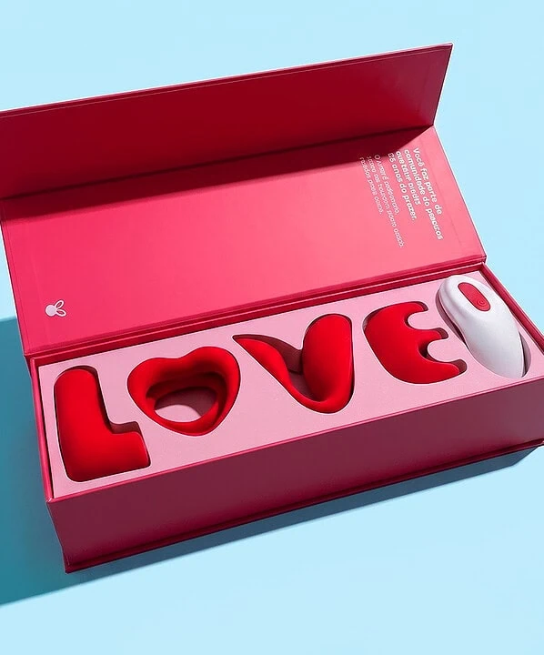Brinquedo de pelúcia em forma de coelho com a palavra "LOVE" em caixa rosa.