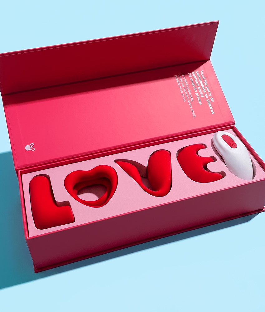 Brinquedo de pelúcia em forma de coelho com a palavra "LOVE" em caixa rosa.
